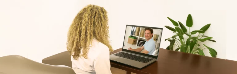 Coach met laptop in gesprek tijdens een coachsessie